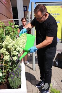 Eko-Donice przed Ełckim Centrum Kultury, prezydent Ełku z uczestnikami Centrum Integracji Społecznej, sadzenie kwiatów